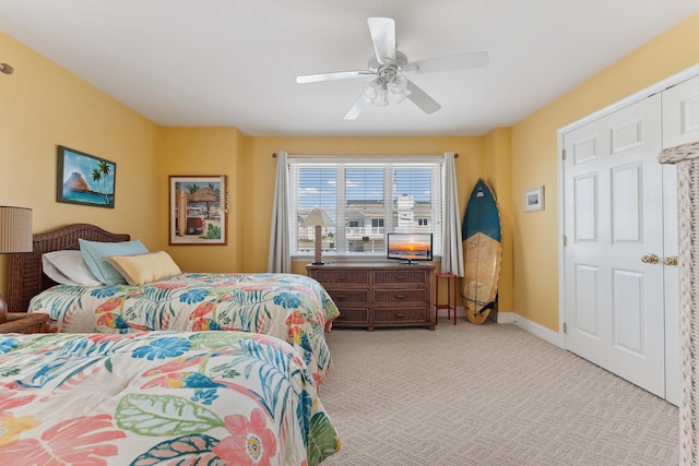 bedroom with a ceiling fan, light colored carpet, and baseboards