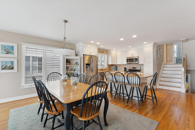 dining area with light wood-style floors, recessed lighting, stairway, and baseboards