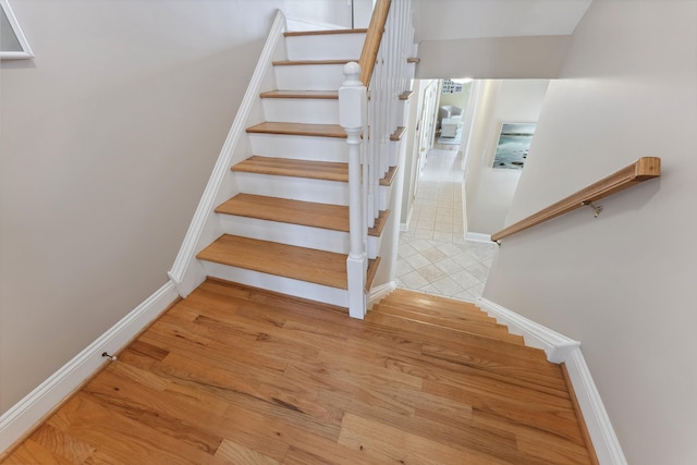 stairway featuring baseboards and wood finished floors