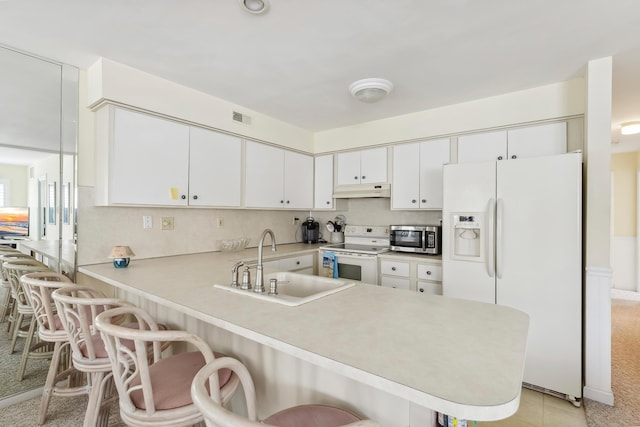 280 79th St Unit 4, Avalon, NJ 08202 - kitchen with white appliances, a sink, a peninsula, light countertops, and a breakfast bar