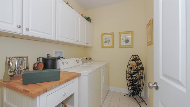 washroom with cabinets, light tile patterned floors, and washing machine and dryer