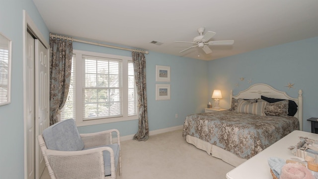 carpeted bedroom with ceiling fan and a closet