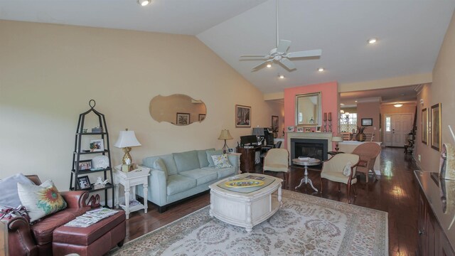 living room featuring vaulted ceiling, ceiling fan, and dark wood-type flooring