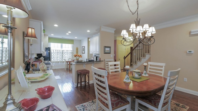 dining area featuring dark hardwood / wood-style flooring, an inviting chandelier, and crown molding