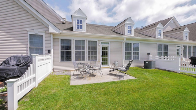 rear view of property featuring a patio area, a yard, and central AC