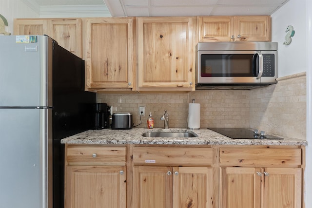 kitchen featuring sink, stainless steel appliances, light stone countertops, light brown cabinetry, and decorative backsplash