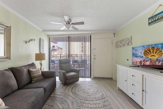 living room with ceiling fan, ornamental molding, a textured ceiling, and light wood-type flooring