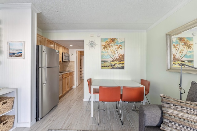 dining area featuring ornamental molding, a textured ceiling, and light hardwood / wood-style floors