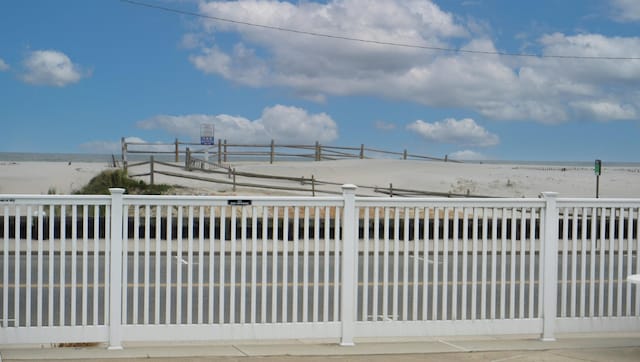 view of gate with a beach view