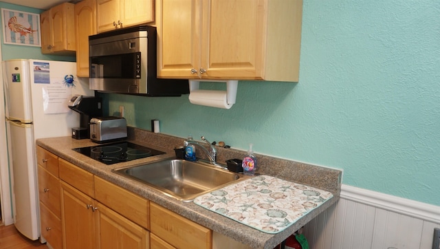 kitchen with white refrigerator, black electric cooktop, sink, and light brown cabinets