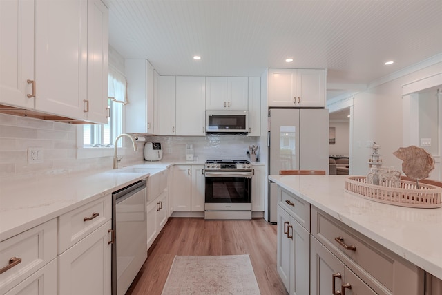 963 Tecumseh Rd, Erma, NJ 08204 - kitchen with appliances with stainless steel finishes, light wood-type flooring, light stone countertops, white cabinetry, and recessed lighting