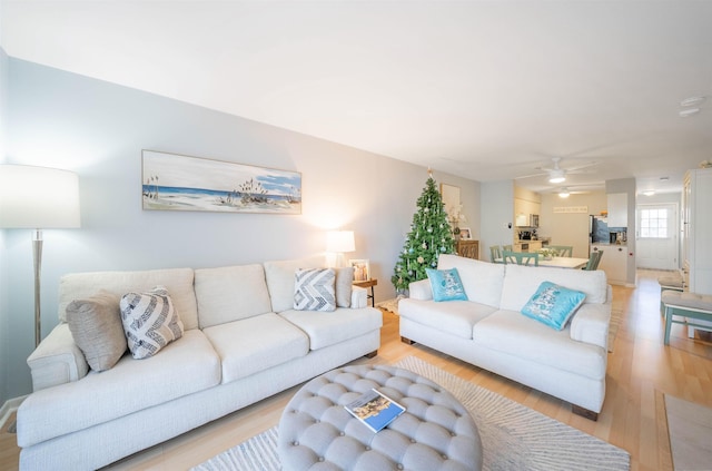 living room featuring light wood-type flooring and ceiling fan