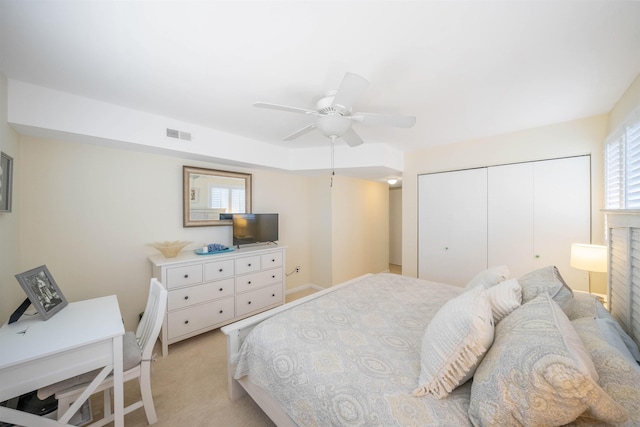 bedroom featuring ceiling fan, a closet, and light carpet