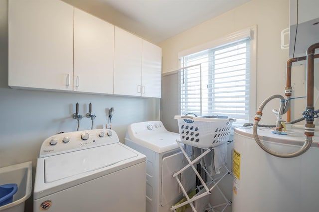 laundry area featuring cabinets, washing machine and clothes dryer, sink, and water heater