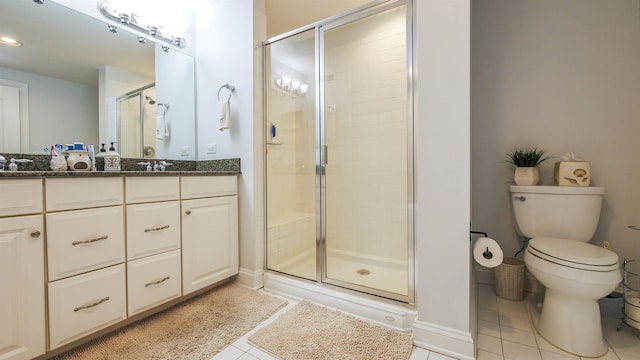 bathroom featuring vanity, toilet, a shower with shower door, and tile patterned flooring