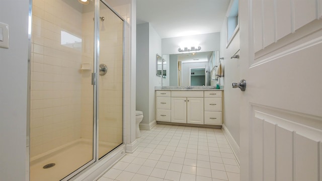 bathroom featuring vanity, tile patterned flooring, a shower with door, and toilet