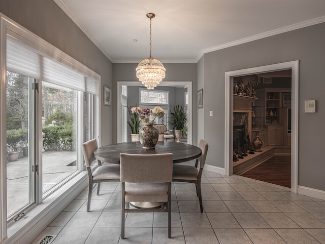 tiled dining room featuring a chandelier, a wealth of natural light, and crown molding