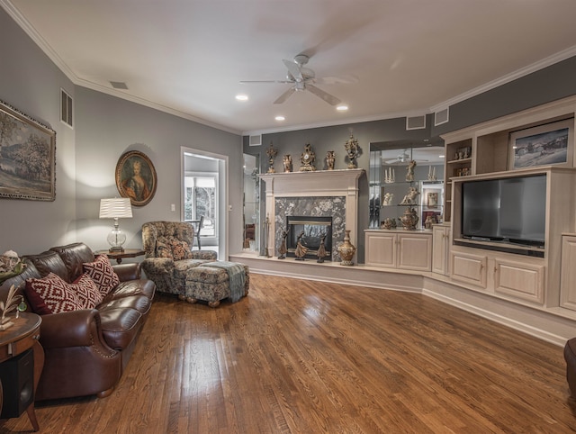 living room with a fireplace, wood-type flooring, ceiling fan, and ornamental molding