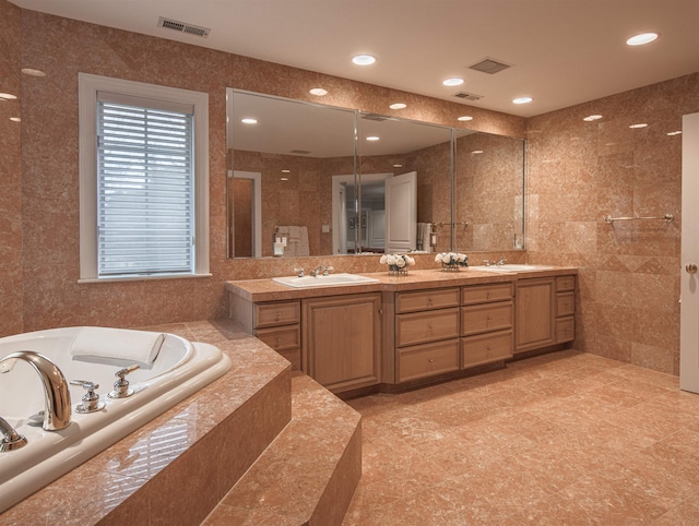 bathroom featuring tiled bath and vanity