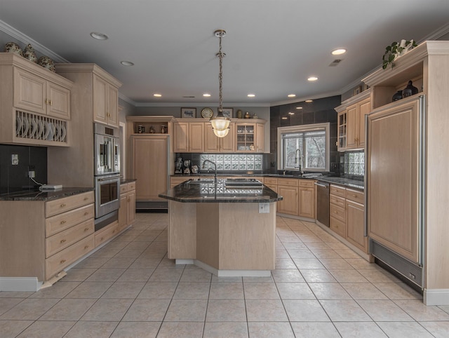 kitchen with a kitchen island with sink, light brown cabinetry, light tile patterned flooring, and appliances with stainless steel finishes