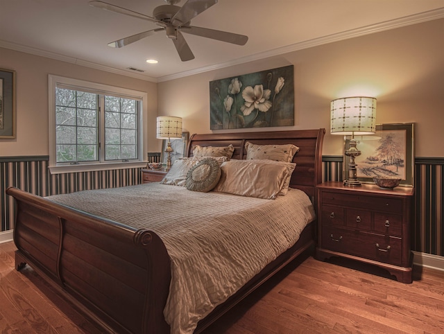 bedroom featuring ceiling fan, crown molding, and wood-type flooring