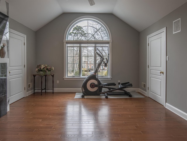 workout room with dark hardwood / wood-style flooring and vaulted ceiling