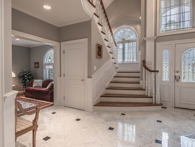 entryway with a wealth of natural light and crown molding