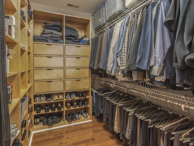 spacious closet with dark hardwood / wood-style flooring