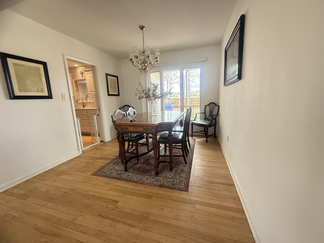 dining room featuring an inviting chandelier, baseboards, and light wood finished floors