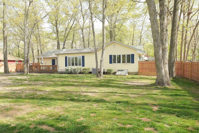 rear view of house with central air condition unit, a yard, fence, and a wooden deck