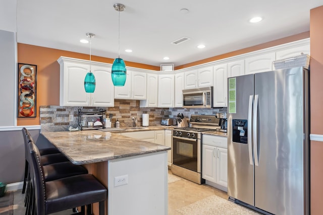 415 E Heather Rd Unit 202, Wildwood Crest, NJ 08260 - kitchen with appliances with stainless steel finishes, a peninsula, light stone countertops, white cabinetry, and tasteful backsplash