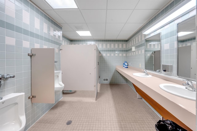 bathroom with vanity, a paneled ceiling, toilet, and tile walls