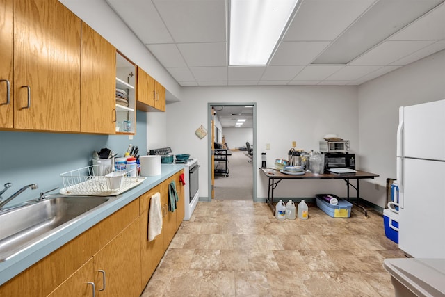 kitchen featuring a paneled ceiling, sink, and white appliances