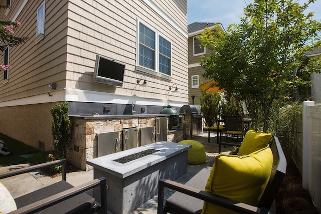 view of patio with area for grilling, grilling area, and a fire pit