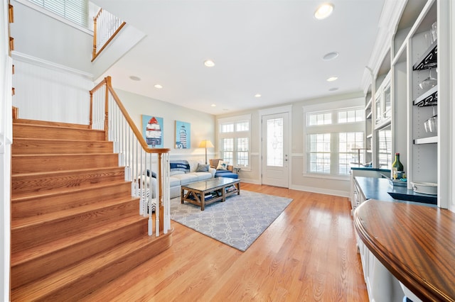 living room with light wood-type flooring and ornamental molding