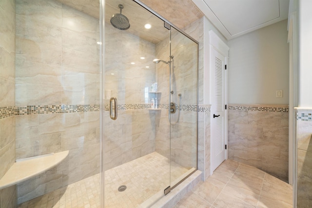 bathroom featuring walk in shower, tile patterned floors, and tile walls