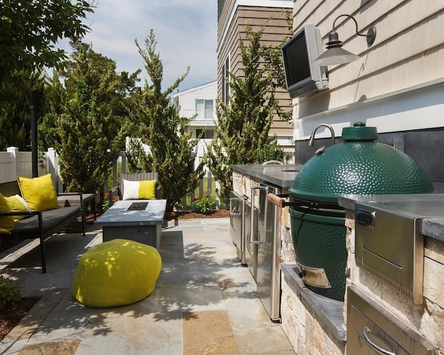 view of patio with area for grilling and a fire pit