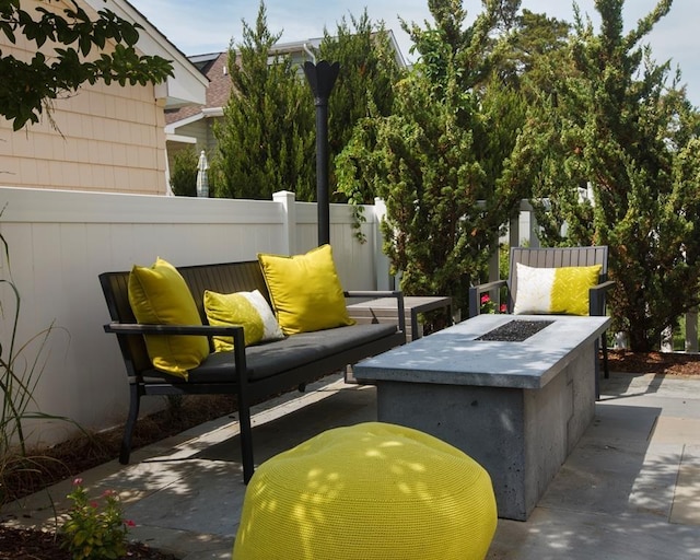 view of patio with an outdoor living space with a fire pit