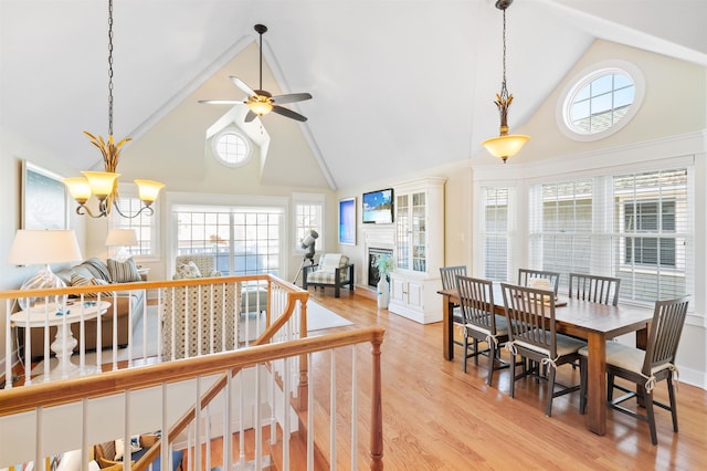 interior space with high vaulted ceiling, light hardwood / wood-style floors, and ceiling fan with notable chandelier