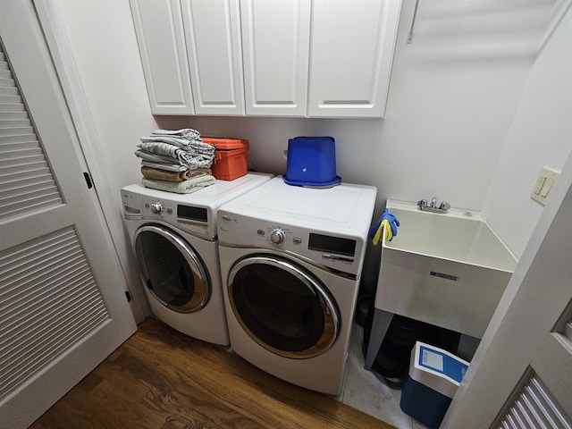 washroom featuring washer and clothes dryer, sink, cabinets, and dark wood-type flooring