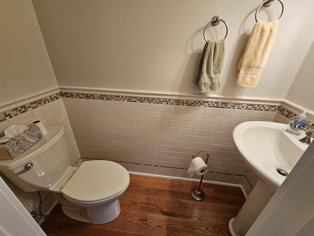 bathroom with sink, wood-type flooring, tile walls, and toilet