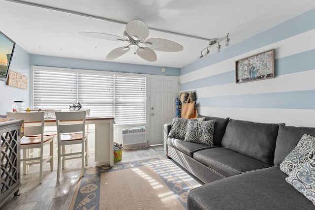 living room featuring track lighting, a wall unit AC, and ceiling fan