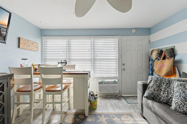 interior space featuring a breakfast bar area, ceiling fan, plenty of natural light, and light wood-type flooring