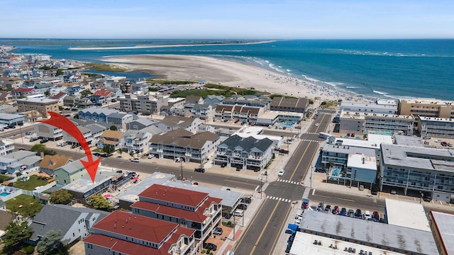 drone / aerial view with a water view and a beach view