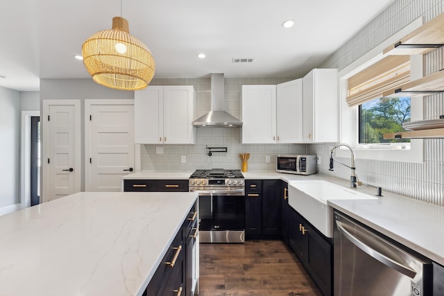 401 Fern Rd, Cape May Beach, NJ 08251 - kitchen featuring wall chimney range hood, stainless steel appliances, a sink, white cabinets, and recessed lighting