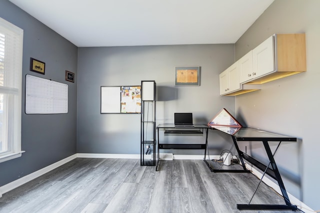 office area with light wood-style flooring and baseboards