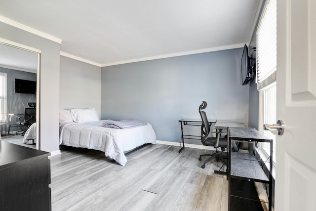 bedroom featuring light wood-style floors, baseboards, and crown molding