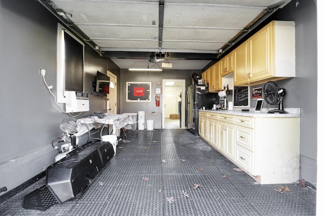 kitchen featuring freestanding refrigerator, light countertops, and dark colored carpet