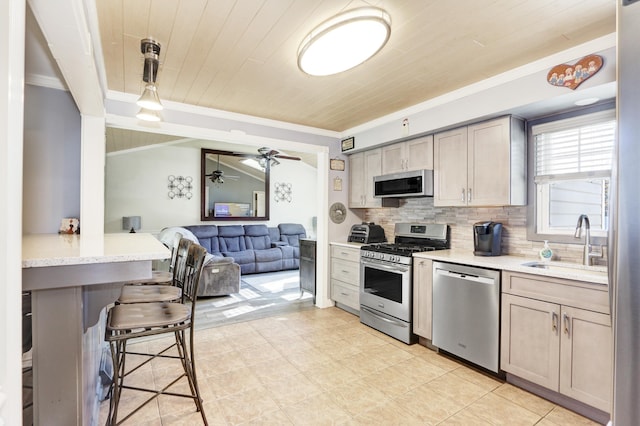 kitchen with a sink, wood ceiling, hanging light fixtures, appliances with stainless steel finishes, and tasteful backsplash