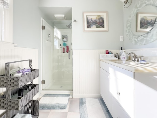 bathroom featuring a wainscoted wall, a stall shower, and vanity